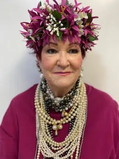 A woman with a flower crown and pearls.